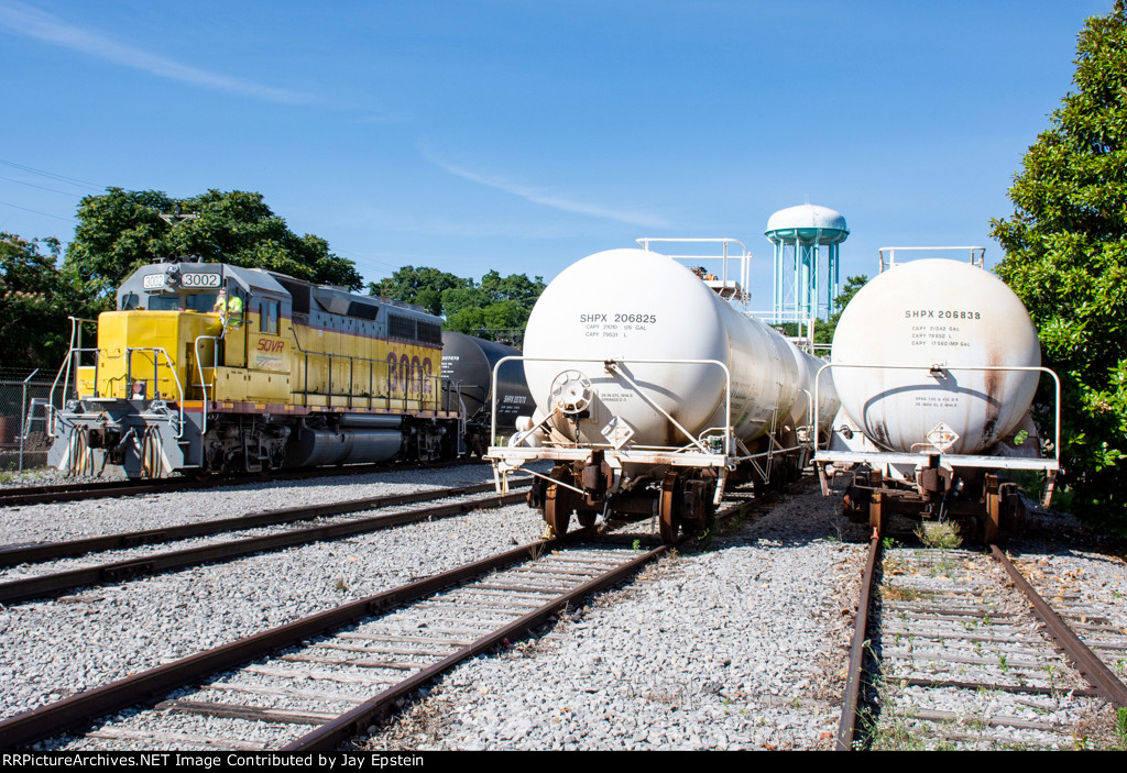 SQVR 3002 poses next to some tank cars